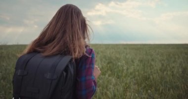 Yeşil bir tarlada yürüyen Kafkas romantik kadın. Çevre koruma ve doğa ile birlik kavramı. Yüksek kalite 4k görüntü