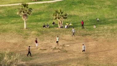 Parkta futbol oynayan hava manzaralı çocuklar eğleniyor. Topla birlikte açık hava eğlencesi. Yüksek kalite 4k görüntü