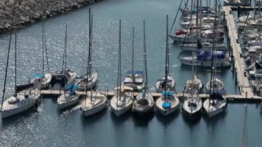 Lüks yatların ve katamaranların demirlediği marinanın havadan görünüşü. Denizde dinlenmek, turizm, çok katlı teknelerle liman. Yüksek kalite 4k görüntü