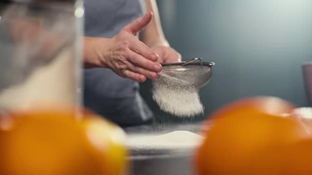 ふるいを通して小麦粉をふるいにかける女性の手のクローズアップ 台所で自宅で生地を作るプロセスのスローモーションビデオ 高品質4K映像 — ストック動画