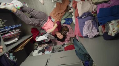 Avrupalı bir kadın gardıroba kıyafet sererken eğleniyor. Moda yaşam tarzı güzel kız kıyafet seçer. Yüksek kalite 4k görüntü