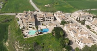 Kıbrıs adasındaki kır evlerinin havadan görünüşü. Sakin bir yerde yeşil sokakları olan bir yerleşim yeri. Yüksek kalite 4k görüntü