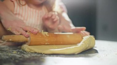 Bir anne küçük kızına hamur işlerini nasıl yapacağını öğretir. Aile mutfakta birlikte pereg için mangırı hazırlar. Takım çalışmasının yaşam tarzı. Yüksek kalite 4k görüntü