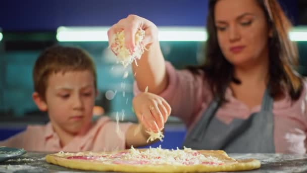 어머니와 아들은 부엌에서 피자에 치즈를 곁들인다 가족은 집에서 요리를 자녀와 — 비디오