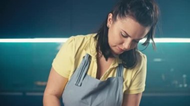 Beyaz bir kadın mutfakta yemek pişirmek için hamur topluyor. Ev yapımı ekmek, kek ve turta hazırlama ve pişirme. Yüksek kalite 4k görüntü