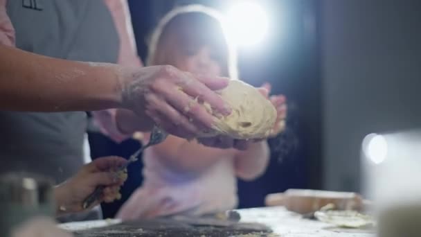 女儿帮妈妈把面团拿出来烘烤 这家人在厨房里一起做饭 高质量的4K镜头 — 图库视频影像