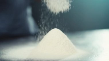 Un süzgeçten elek geçirirken yavaş çekim videosu. Hamuru pişirmeye hazırlama süreci. Yüksek kalite 4k görüntü