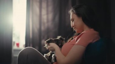 Beyaz kadın evde evcil hayvanla eğleniyor. İnsanlara köpek sevgisi. Birlikte mutluyuz. Evde hayvanlı bir aile. Yüksek kalite 4k görüntü