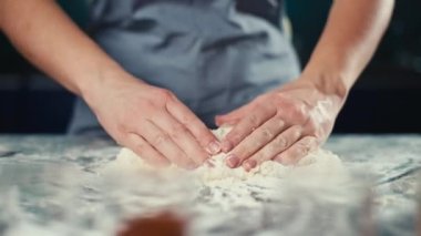 Şef mutfakta elleri ile hamuru yoğurur. Unu hamura çevirmek. Bir profesyonelden pasta, ekmek ve kek. Yüksek kalite 4k görüntü