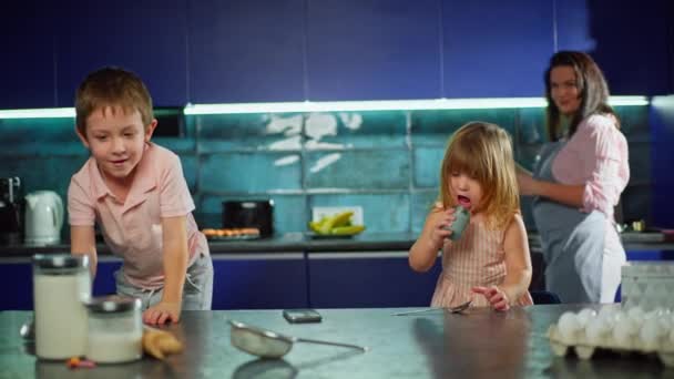 Καυκάσια Παιδιά Διασκεδάζουν Και Χορεύουν Στην Κουζίνα Ενώ Βοηθούν Μητέρα — Αρχείο Βίντεο