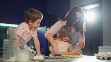 Çocuklar kek pişirmek için annelerine para saçmalarında yardım ediyorlar. Mutlu bir aile birlikte çalışır, ebeveynler oğullarına ve kızlarına öğretir. Mutluluğun yaşam tarzı. Yüksek kalite 4k görüntü