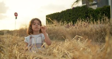 Tatlı bir kız rüyasında tarlada oturur ve samanlara düşer. Çocuk ve doğa kavramı, bir çocukla bir çiftlikte çalışmak. Yüksek kalite 4k görüntü