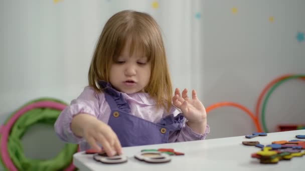 一个漂亮的女孩在幼儿园玩教育游戏的肖像 一个孩子在课堂上收集字谜 高质量的4K镜头 — 图库视频影像
