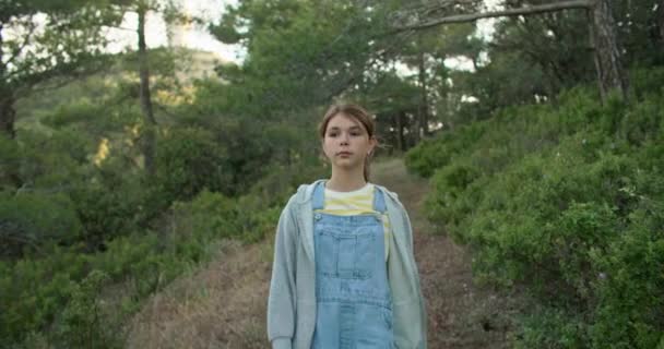 少女は一人で松林の中の道を歩いている 10代の夢は 美しい風景の中に自然のことを考える時間 高品質4K映像 — ストック動画