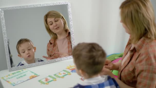 Dziecko Chłopiec Wykonuje Ćwiczenia Dla Rozwoju Mowy Podczas Zajęć Logopedą — Wideo stockowe
