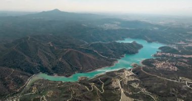 Kıbrıs 'taki dağlardaki rezervuarın havadan görüntüsü. Dağ sıraları arasında barajı olan bir nehir tarafından oluşturulmuş güzel bir göl. Ekoloji ve tatlı su. Yüksek kalite 4k görüntü