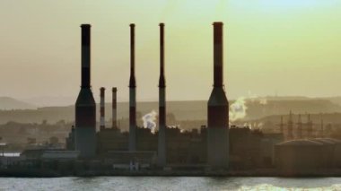 Temiz Enerji Savunması: Bir Enerji Santralinin Drone Aşılarını Duman bacalarıyla vurmak, Çevresel Muhafız ve Ekolojik Sorumluluk İhtiyacını simgeliyor. Yüksek kalite 4k görüntü