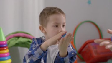 Çocuk, öğretmenle birlikte, sınıfta gelişim oyunları oynuyor. Çocuklarda el hareketliliğinin gelişimi. Yüksek kalite 4k görüntü