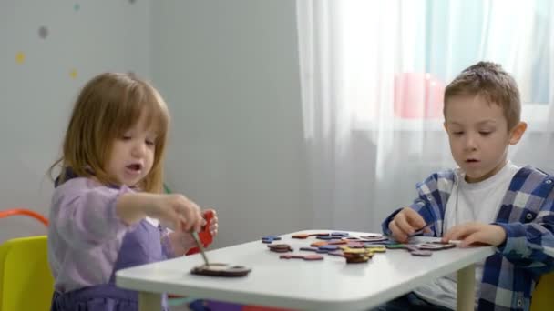 Gyerekek Logikai Játékokat Játszanak Egy Asztalnál Óvodában Egy Fiú Egy — Stock videók
