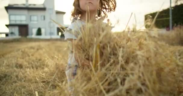 귀여운 소녀는 건초를 올리고 장난을 치면서 재미있게 자연의 농장에서 재미없는 — 비디오