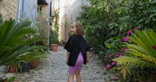 赤ん坊の女の子は美しい建築と古いヨーロッパの都市の通りを歩く 観光や子供とレクリエーションのための新しい場所 高品質4K映像 — ストック動画