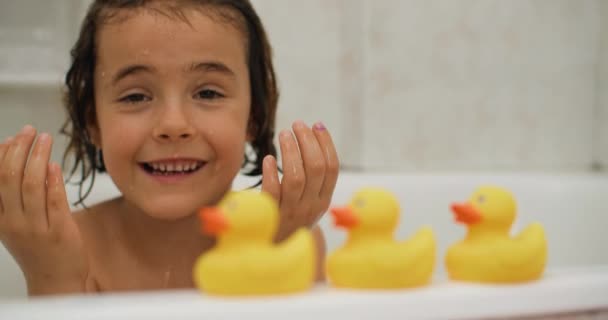 浴室でお風呂に入っている間 白人の女の子がおもちゃで遊んでいます 屈託のない笑顔と幸せの陽気な子供時代 高品質4K映像 — ストック動画