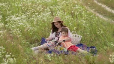 Aile Bağları: Anne Çocuklara Güzel Bir Tarlada Okuyor - Öğrenme ve Kaliteli Zamanda Yetiştirme. Yüksek kalite 4k görüntü