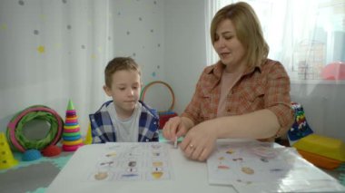 Anaokulundaki bir çocuk anaokulunda öğretmeniyle tek başına çalışır. Çocuk harf öğreniyor ve okul hazırlığı için eğitici oyunlar oynuyor. Yüksek kalite 4k görüntü