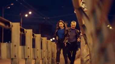 Çıplak adam ve kız gece şehrinde dans ediyorlar. Şehir manzarası hafif araba farları sokak lambaları ve birkaç dans eden modern dans. Yüksek kalite 4k görüntü