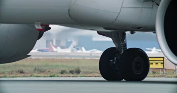 ダイナミッククローズアップフッテージ 活気のある空港ランウェイに沿って滑走する飛行機ホイールの魅惑的な眺め 高品質の4K映像 — ストック動画