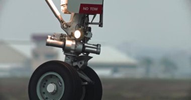 Heyecan 'ın açılışı: yaz pistinde zarifçe süzülürken yakın plan uçak tekerlekleri. Yüksek kalite 4k görüntü