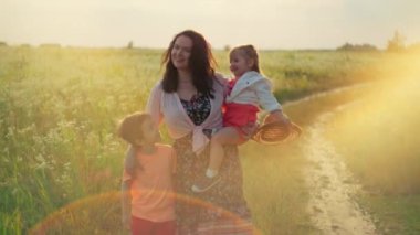 Serene European Mother, Daughter ve Oğlu Sunset 'teki Verdant Meadow' da tuhaf bir yolculuğa çıkıyorlar. Neşeli çocukluk ruhunu kucaklıyorlar. 