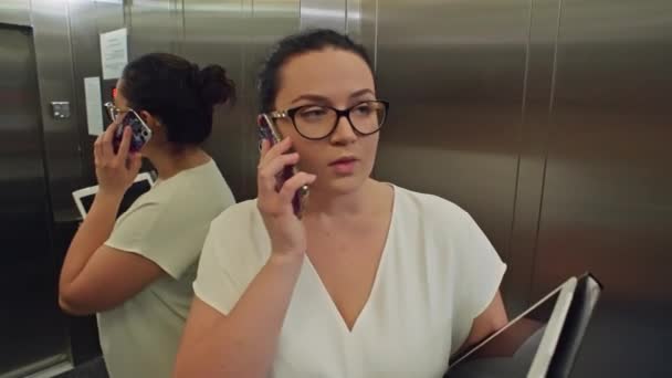 生产性电梯 女商人管理文档 表格和智能手机在前往商务中心会议的路上 高质量的4K镜头 — 图库视频影像