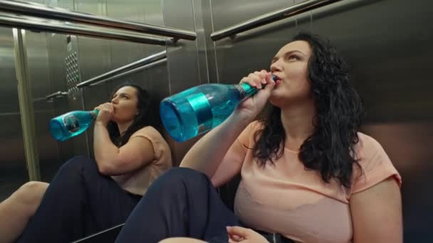 ナイトライフアドベンチャー シャンパンのボトルでエレベーターのグラマラスなアウトフィットヘッディングの女の子 高品質の4K映像 — ストック動画