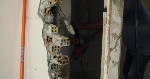 慢镜头 一个男人用手提钻推倒一堵墙 拆卸和准备房舍供修理 高质量的4K镜头 — 图库视频影像