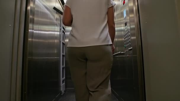 効率的な通勤 オフィスセンターエレベーターに入るブリーフケースとタブレットを持つビジネスマン 滑らかな垂直輸送を開始します 高品質の4K映像 — ストック動画