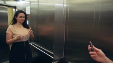 Beyaz bir kadın asansöre biner ve partiden önce dudaklarını boyar. Kızın randevuya gitmek için acelesi var. Yüksek kalite 4k görüntü