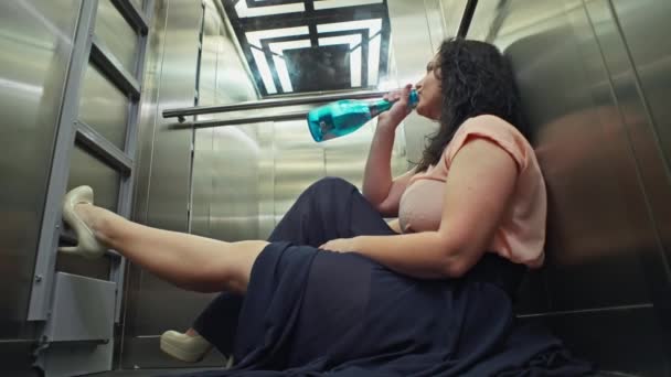 パーティー後にエレベーターに乗るシャンパンのボトルを持った白人女性 酔っ払った女性が帰宅 高品質の4K映像 — ストック動画