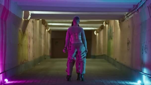 地下节奏 年轻男子和女子在一个昏暗的行人过道的高跟鞋上跳自由式舞 高质量的4K镜头 — 图库视频影像