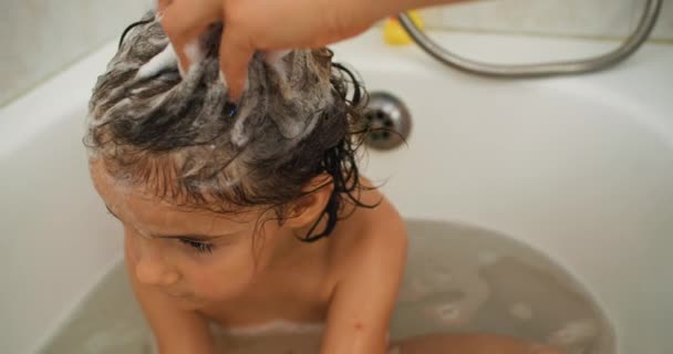 沐浴时间的喜悦 作为一个慈爱的母亲 创造珍爱的回忆 用欢乐的泡沫轻柔地洗净她的孩子的头发 高质量的4K镜头 — 图库视频影像