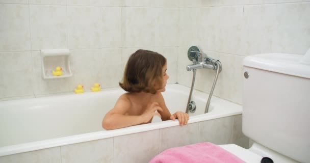 コカシアンの女の子は蛇口を回して風呂に入ります トイレで楽しんでいる子供の幸せ 高品質の4K映像 — ストック動画