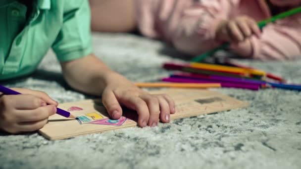 兄弟と姉は自宅の床に鉛筆を描いている 子どもたちは楽しんで 創造性に取り組んでいます ハッピーケアフリーの子供時代 高品質の4K映像 — ストック動画