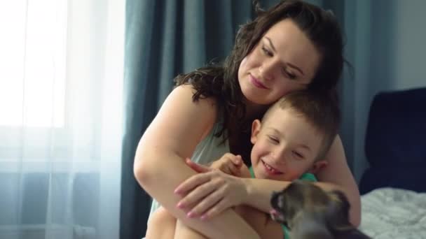 母親は寝室のベッドで息子を抱きしめる 育児と愛のコンセプト 子供時代の幸せな笑顔 高品質の4K映像 — ストック動画