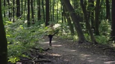 Fitness Hedeflerine Ulaşmak: Virajlı Kadın Ormanda Serene Trail 'de Koşuyor - Sağlık ve Diyet Yolculuğu. Yüksek kalite 4k görüntü