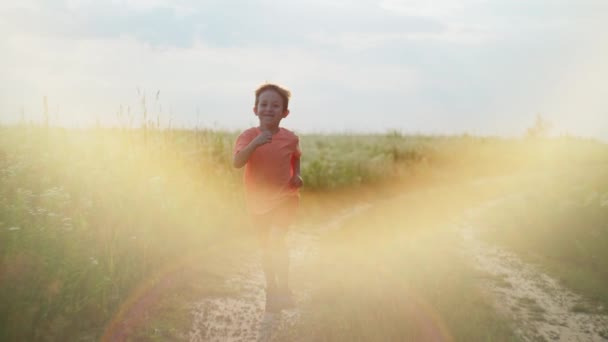 田舎の道を走る男の子のスローモーションビデオ 自然の中で幸せな笑顔の子供時代の概念 高品質の4K映像 — ストック動画