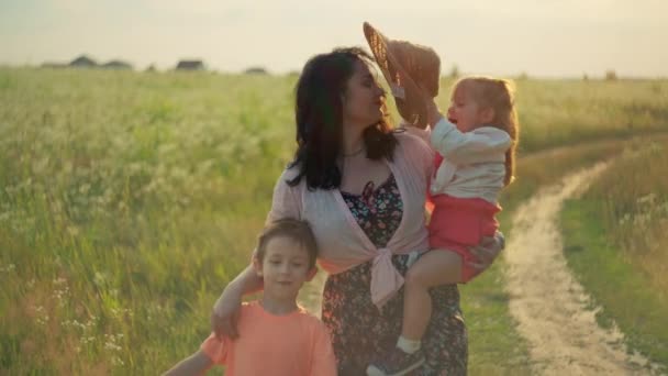美しいヨーロッパの家族 ラッシュグリーンフィールドを歩く夕日を祝い 至福の子供時代 笑顔と暖かさの概念を取り入れる — ストック動画