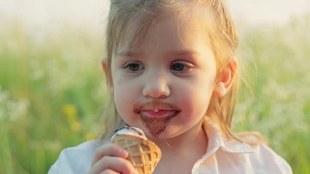 Zbliżenie Białej Dziewczyny Jedzącej Lody Trawie Polu Szczęśliwe Uśmiechnięte Dziecko — Wideo stockowe