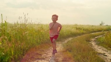 Yavaş çekimde bir çocuğun güneşin altında koştuğunu gösteren bir video. Çocukların özgürlük kavramı rahatlama ve spor hayalleri kurar. Yüksek kalite 4k görüntü