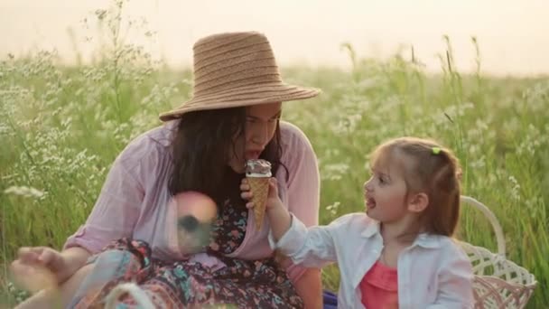 ラッシュグリーンメドウでアイスクリームを楽しむコンテンツに満ちた母とその子供たち 至福の子供時代の本質を描き 家族の至福の本物の笑顔を除く — ストック動画