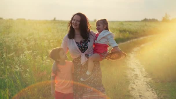 宁静的欧洲母亲 女儿和儿子 在日落时分 在碧绿的草地上异想天开 拥抱着欢乐童年的本质 充满了欢乐 — 图库视频影像